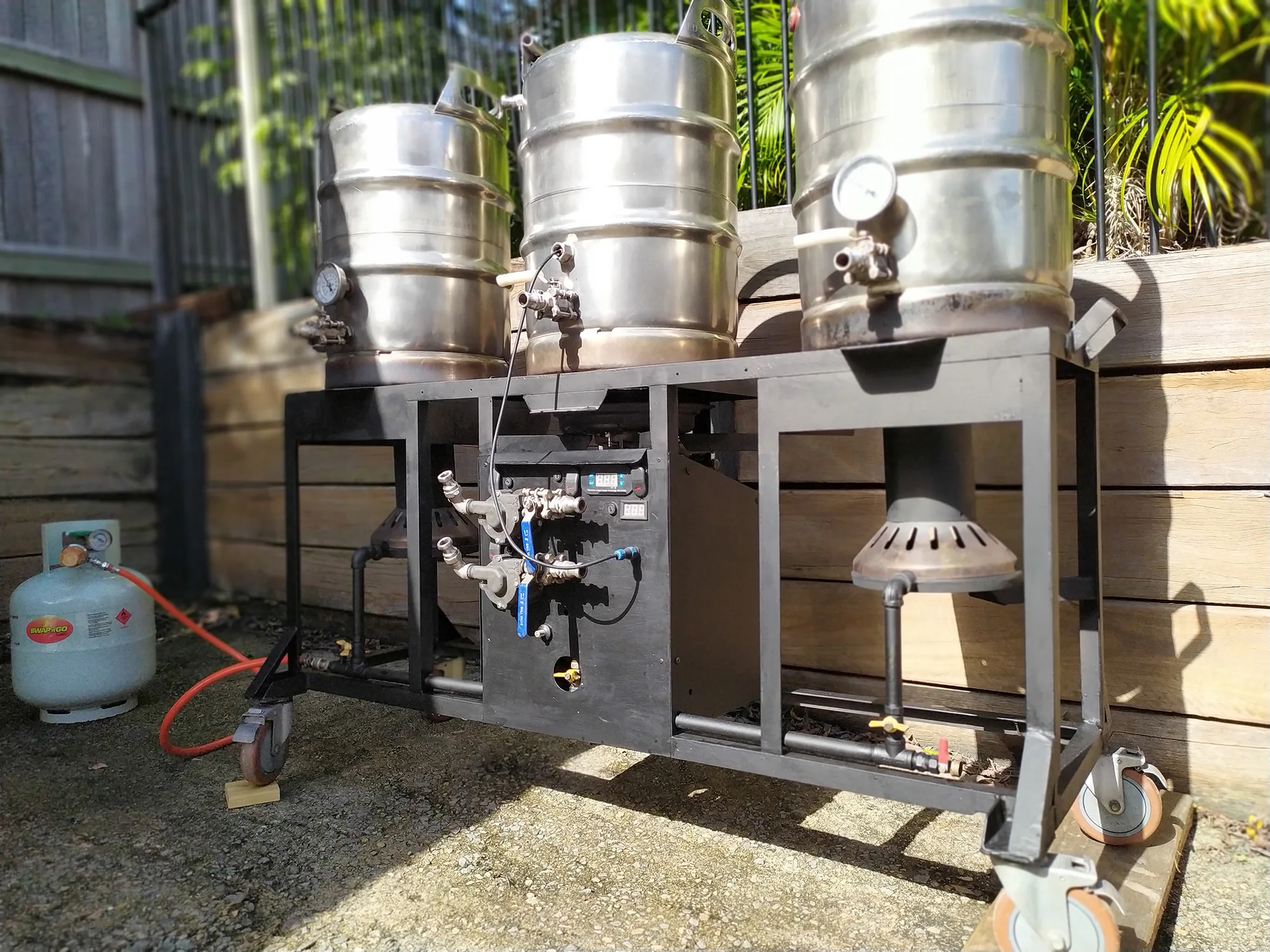 A homebrewing setup with kettles and a mash tun